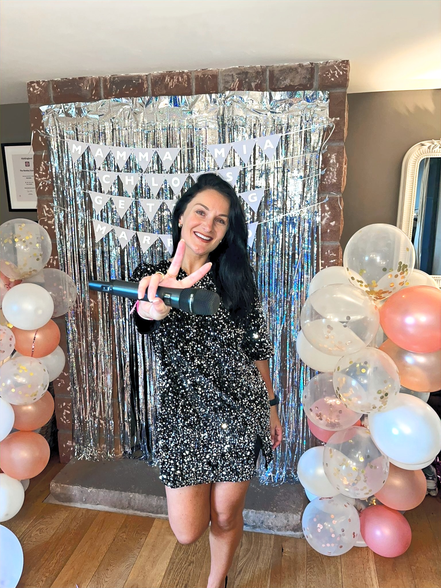 Alicia Ruby holding a microphone at a wedding celebration