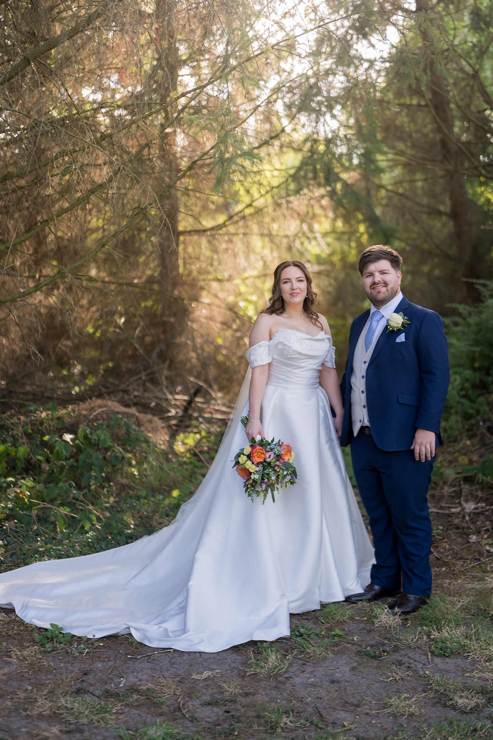 Bethany and Jamie standing among the trees at The Oak Tree of Peover