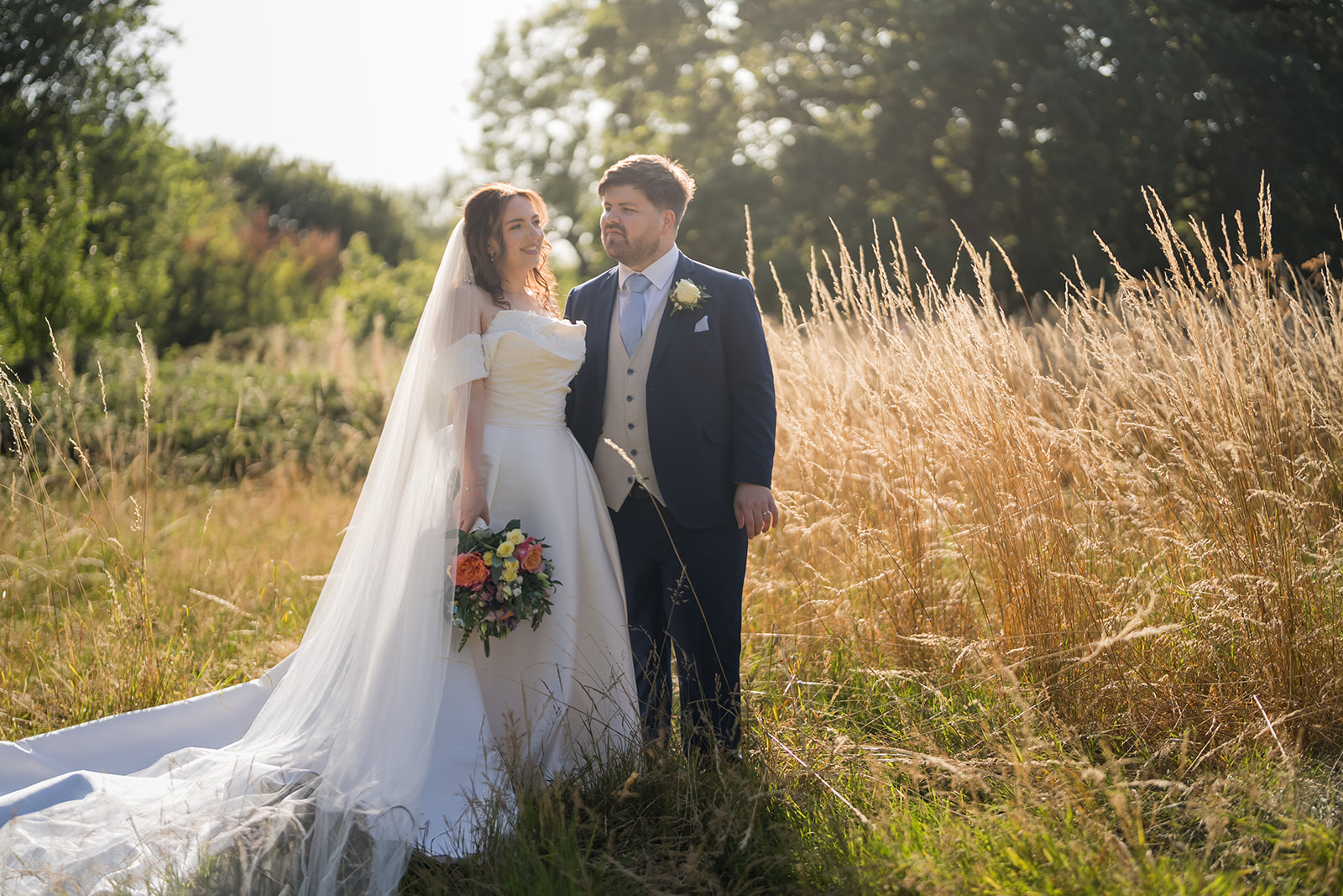 Bethany and Jamie together in the sunlit meadow at The Oak Tree of Peover