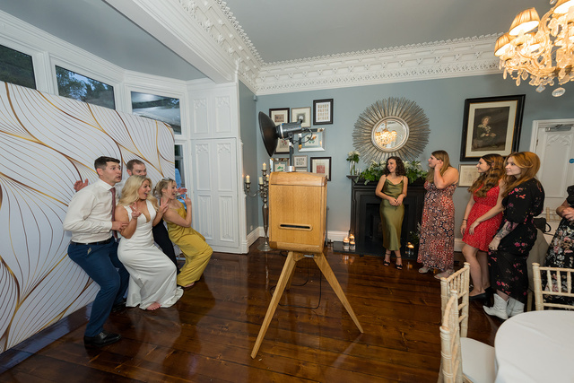 Wedding guests posing together in front of the oak photo booth
