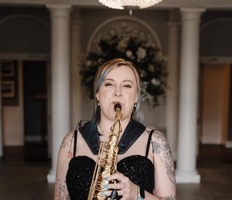 Cat from Saxophonique playing saxophone outside a wedding venue