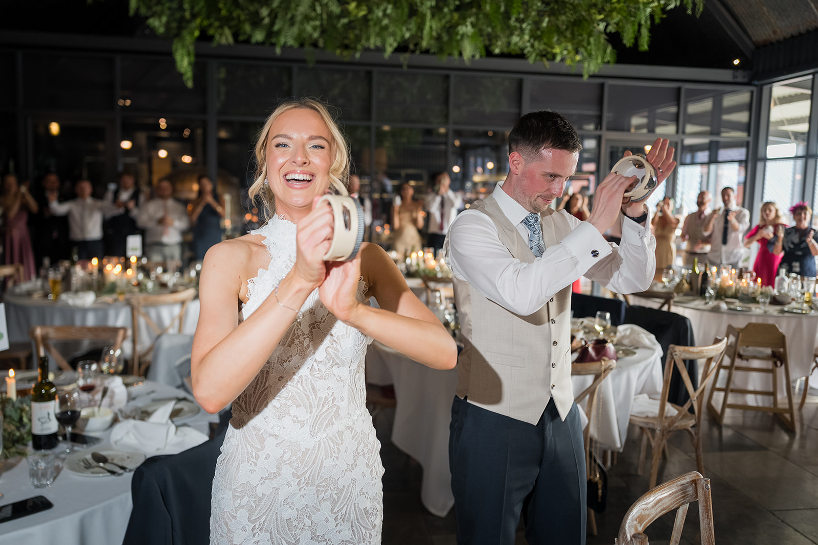 Emma and Jack celebrating with tambourines at their Grangefields reception