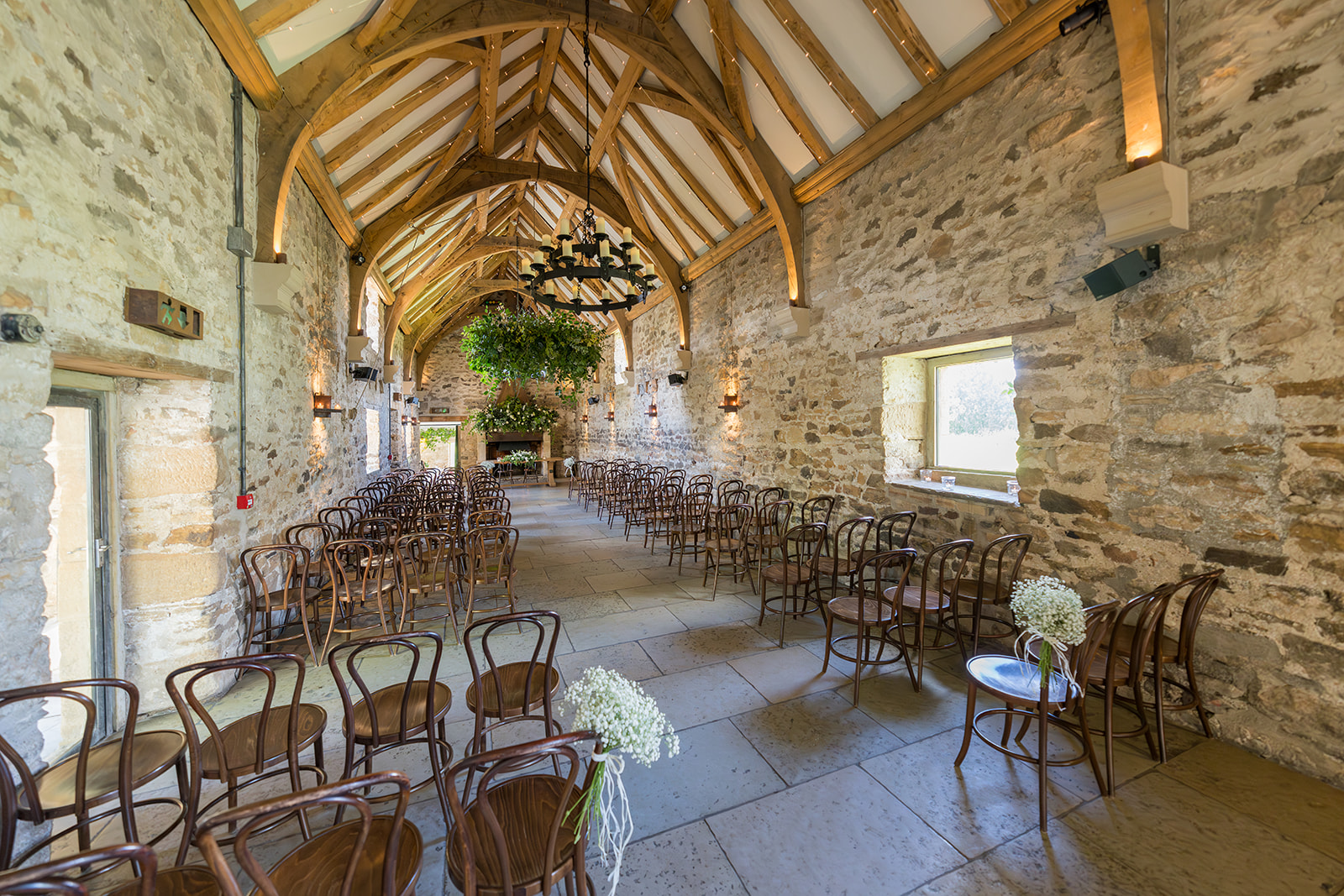 Healey Barn ceremony room with stone walls, oak beams and chairs ready for the wedding