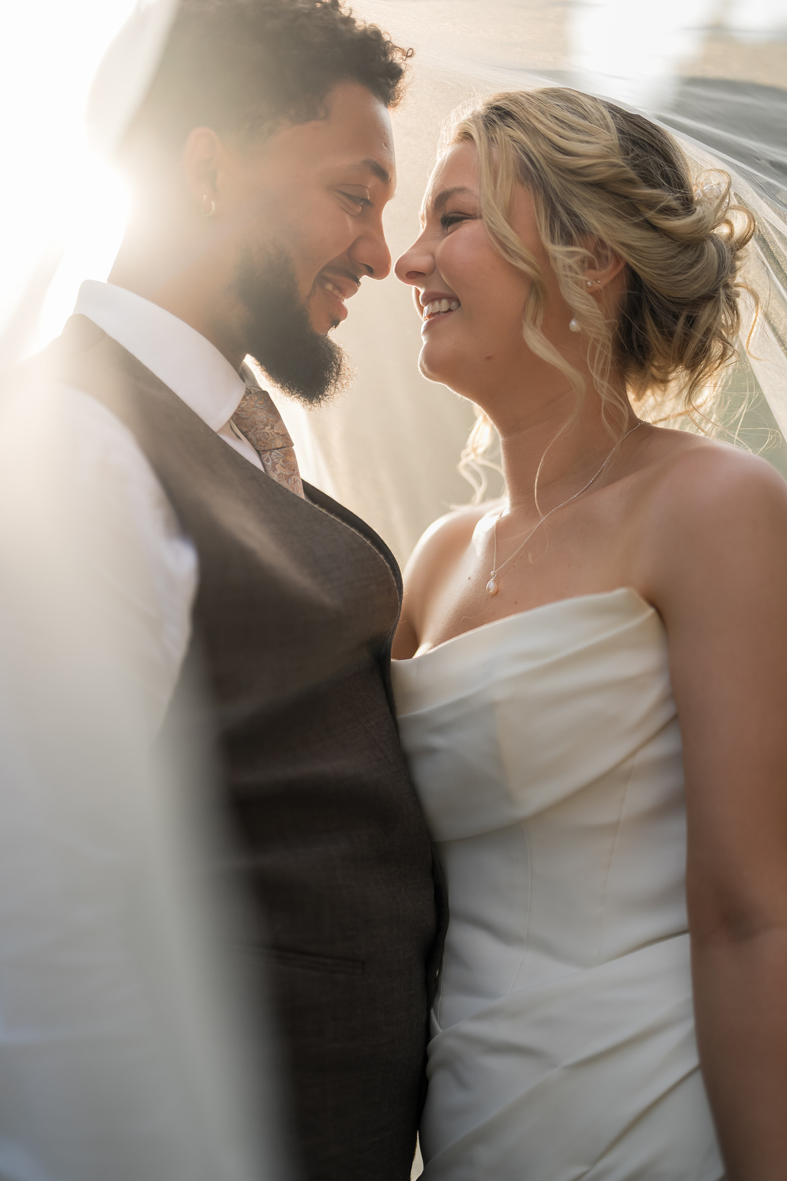 Kate and Jacob smiling together beneath the veil at their Ingestre wedding