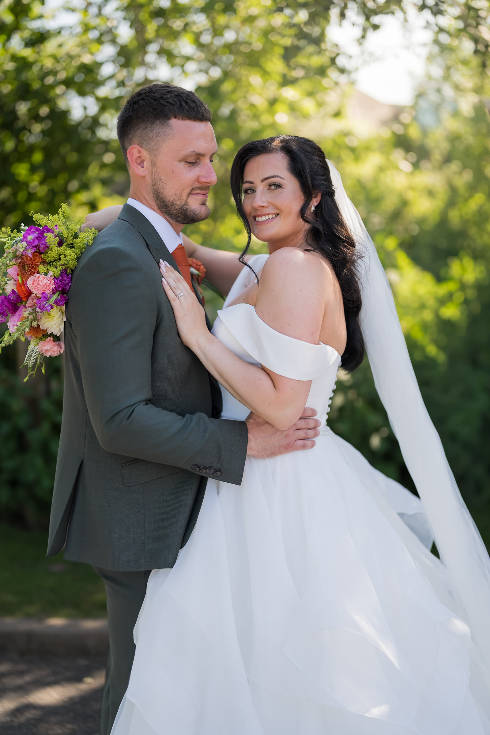 Kate and Kieran with colourful flowers in the grounds of Mythe Barn
