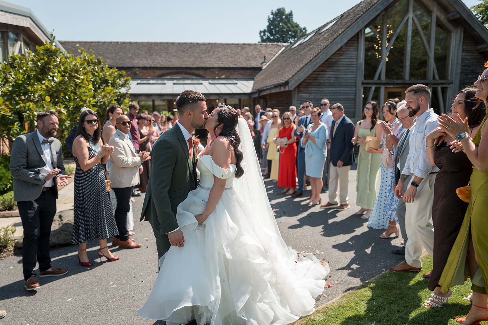 Kate and Kieran kissing in the confetti outside Mythe Barn after their ceremony