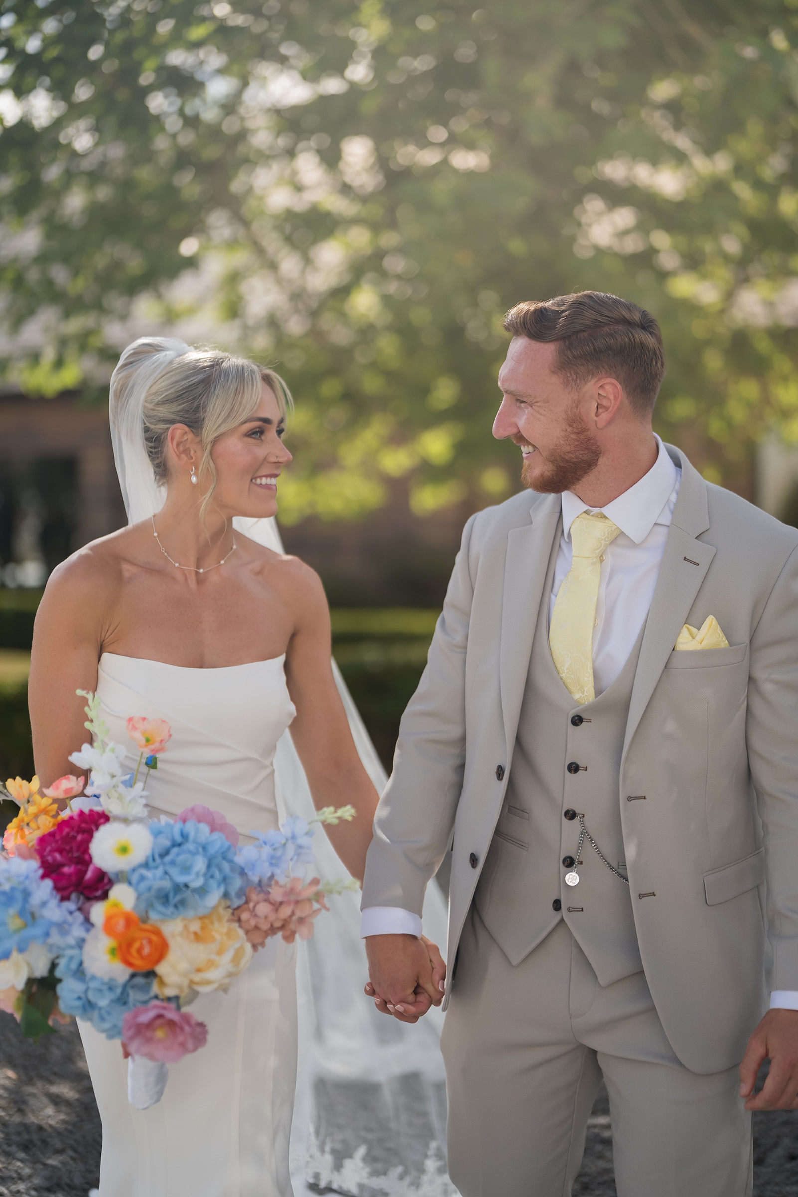 Lauren and Ryan holding hands beneath the trees at The River Barn in Lancashire