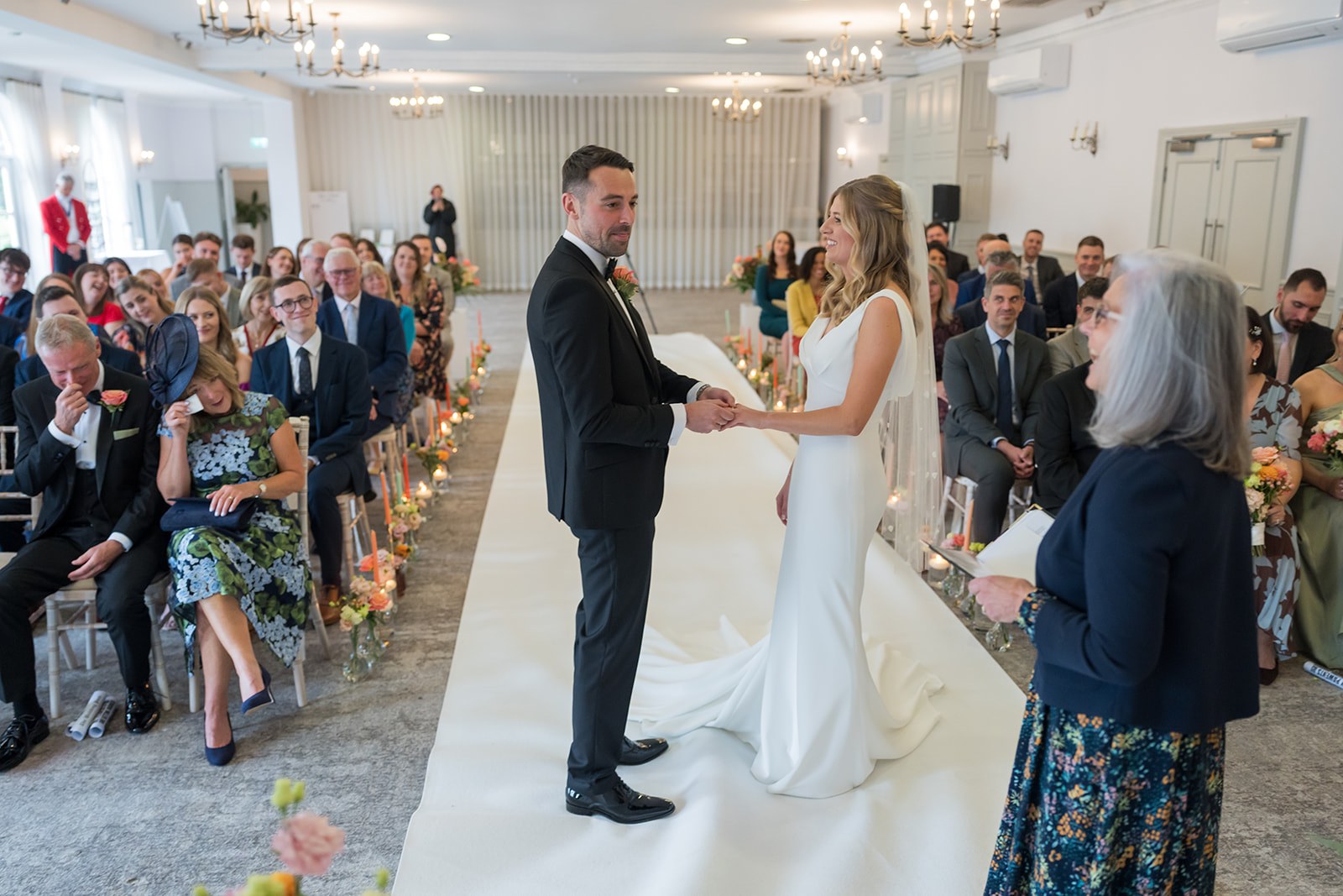 The wedding ceremony with guests watching at Mottram Hall