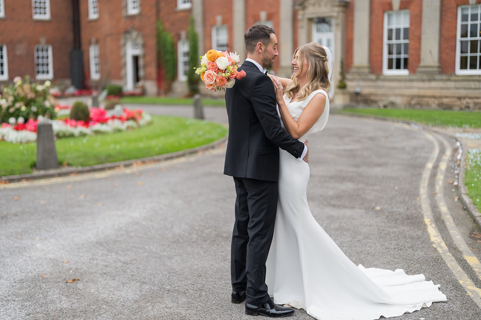 Amy and Daniel together outside Mottram Hall’s red-brick frontage