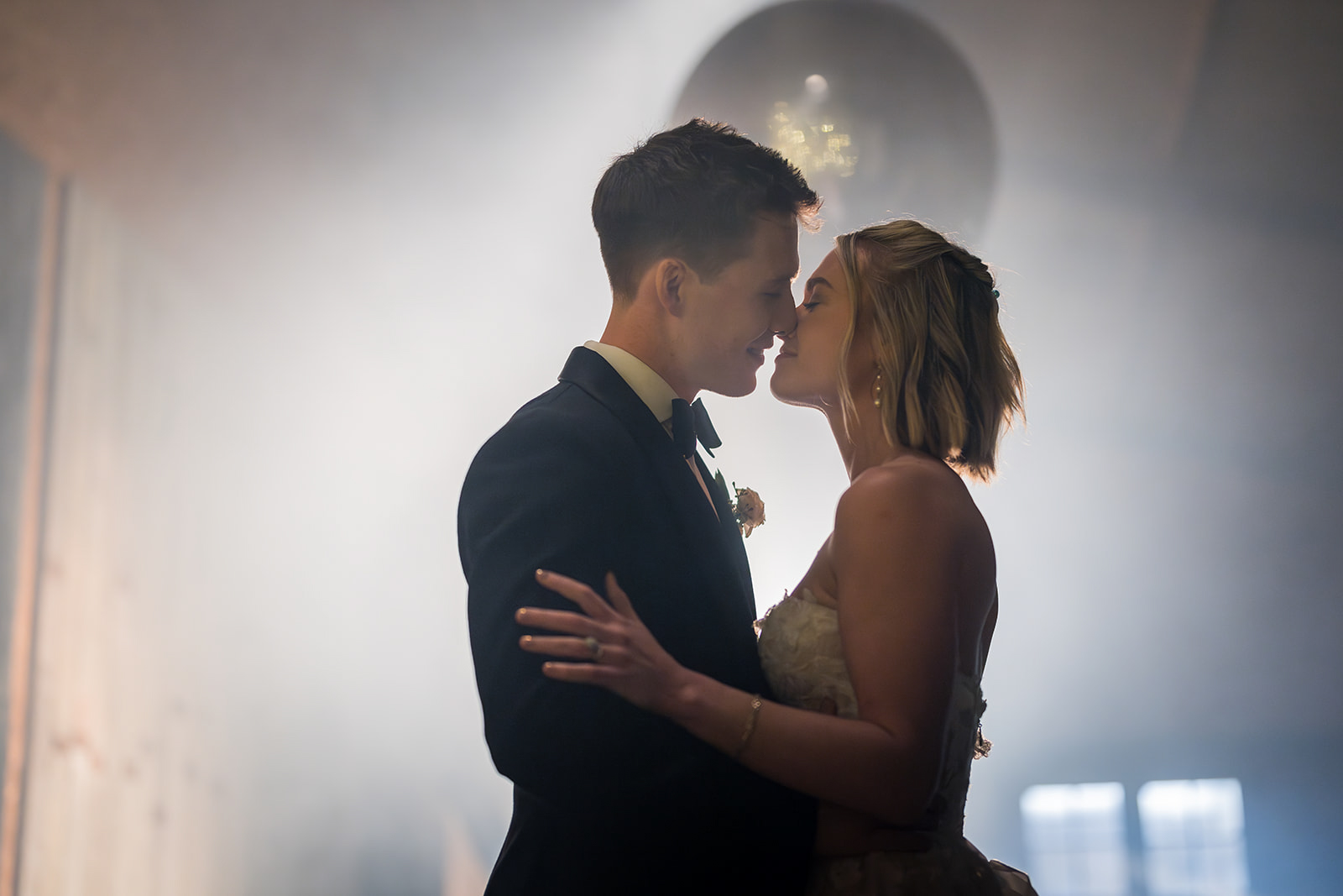 Bride and groom together in atmospheric light inside Owen House Wedding Barn