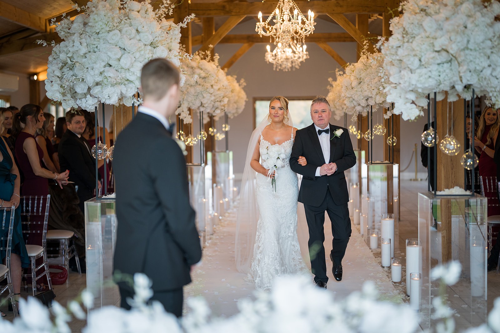 Newlyweds walking down a flower-lined church aisle
