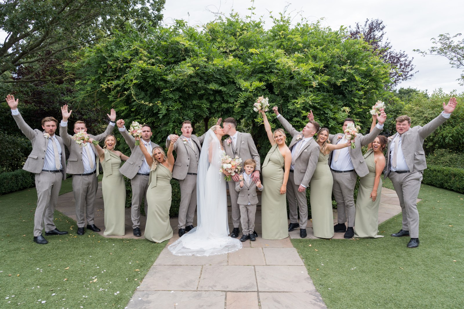 The wedding party celebrating in the gardens at Pryors Hayes