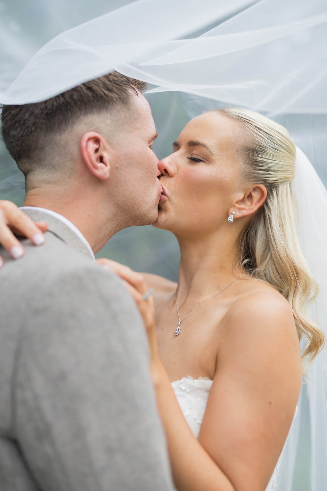 A kiss beneath the wedding veil at Pryors Hayes