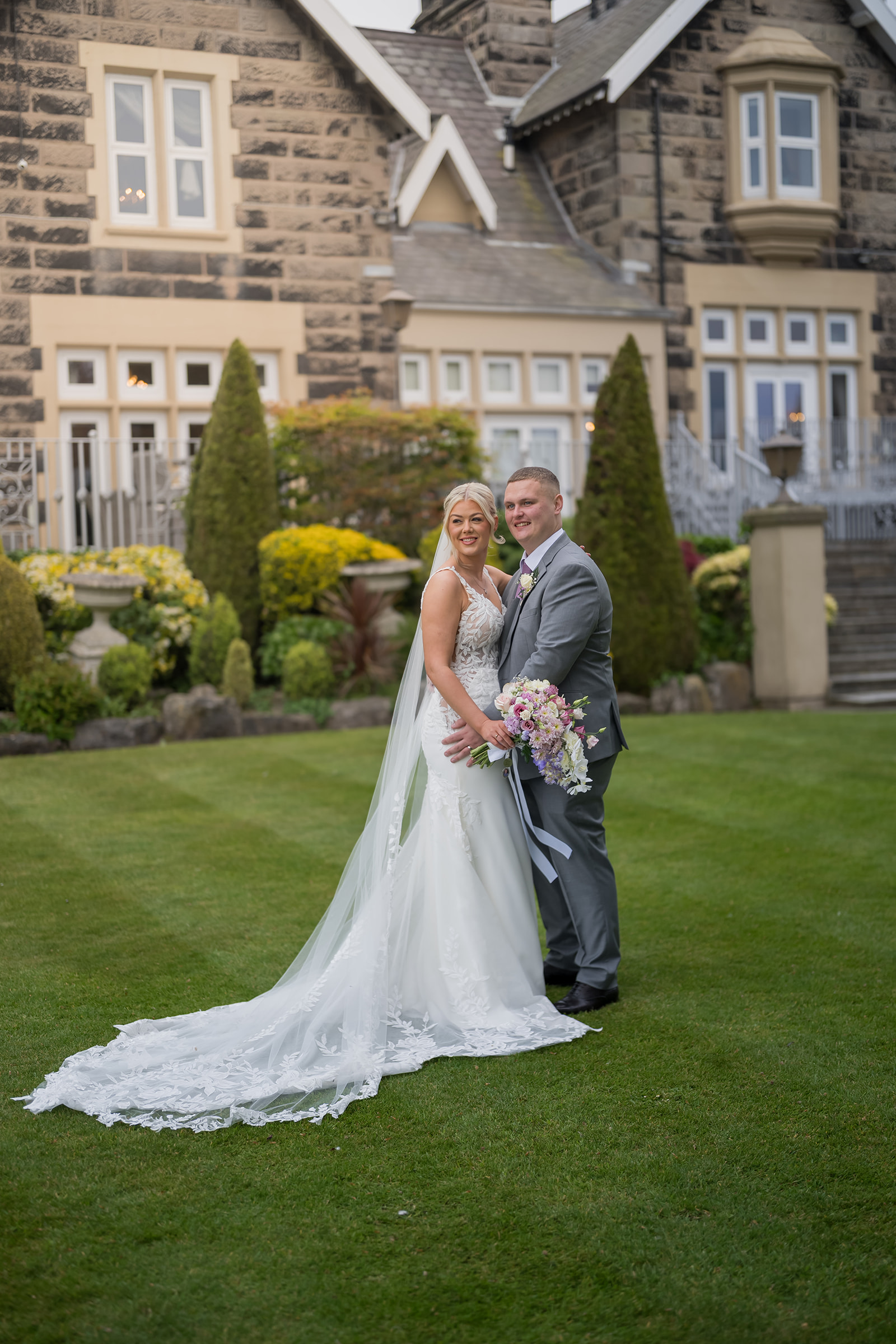 Samantha and Adam on the lawn in front of West Tower country house