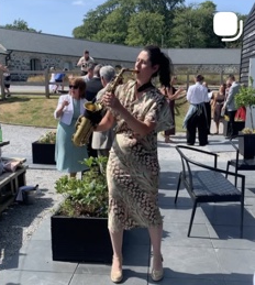 Sophia Sax performing outdoors at a wedding reception