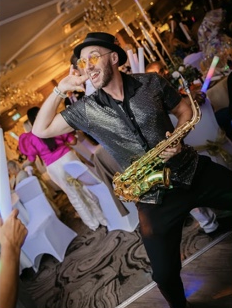 Spencer Moran holding his saxophone while entertaining wedding guests
