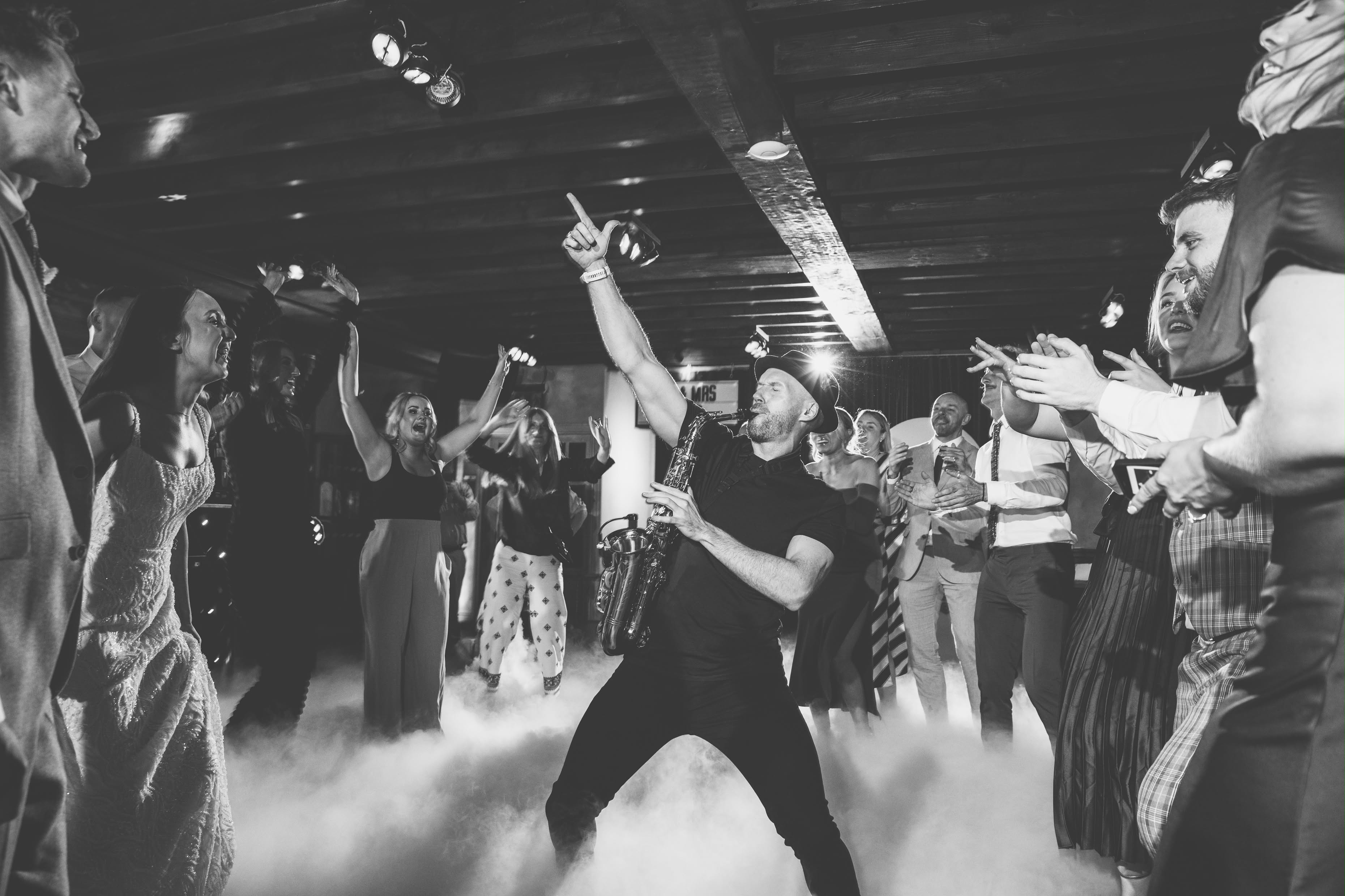 Spencer Sax performing among cheering wedding guests on the dance floor