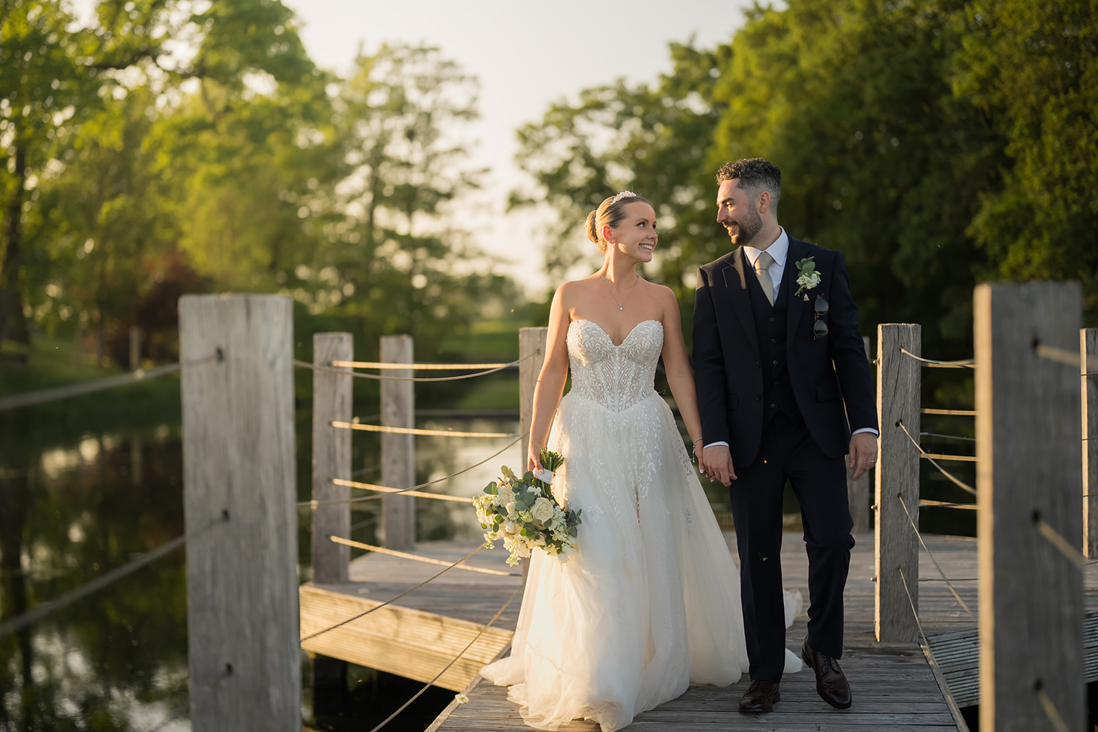 Stephanie and Ben holding hands on the garden bridge at Merrydale Manor