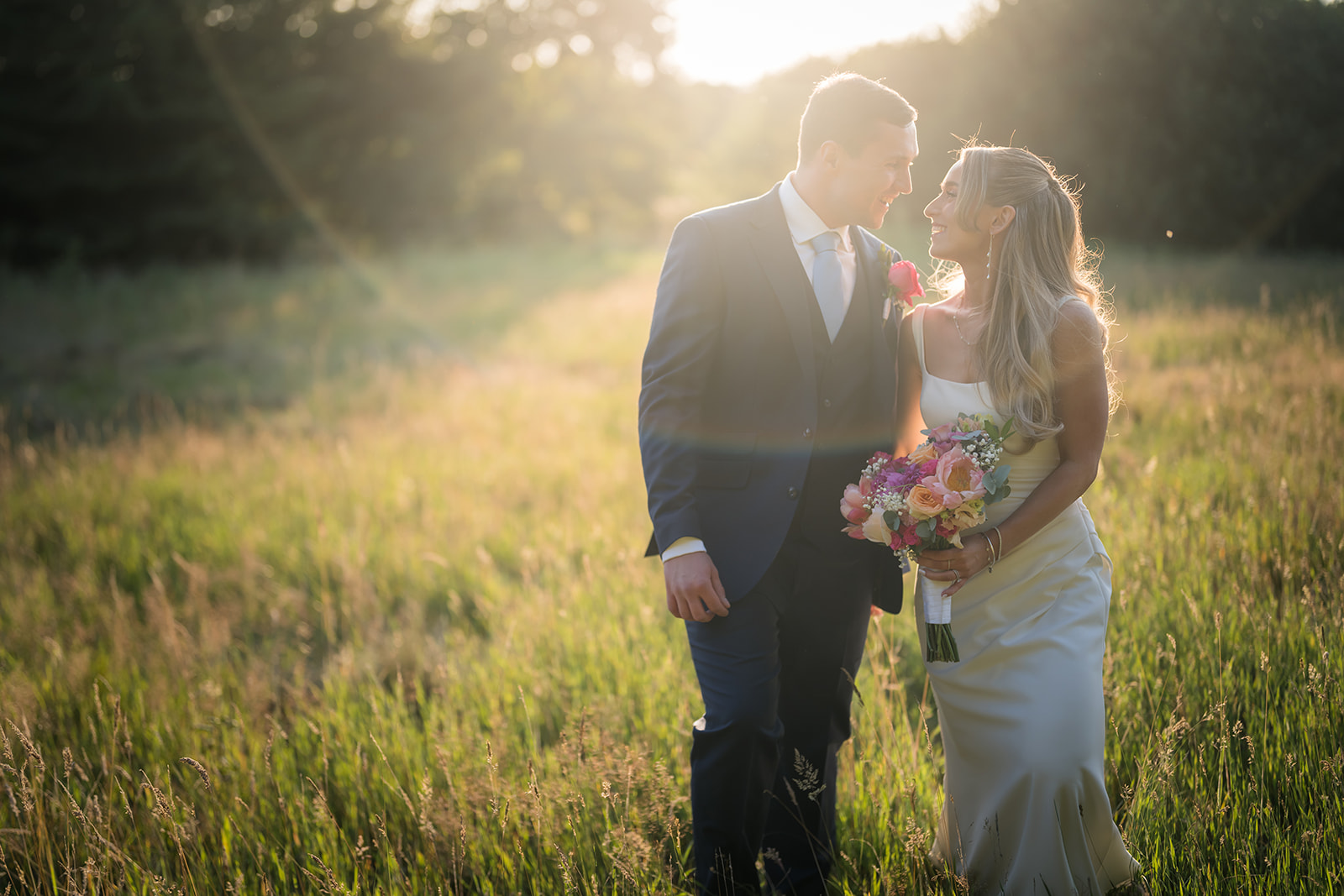 Bride and groom in a sunlit meadow at The Oak Tree of Peover