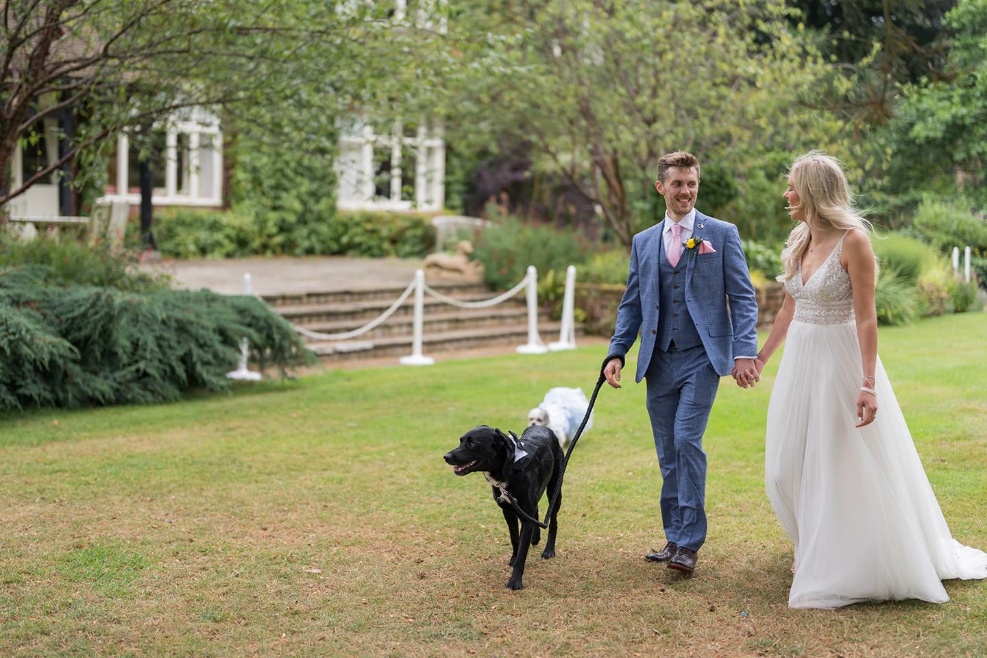 Newlyweds walking with their dogs at Annie and Joe’s Abbeywood Estate wedding