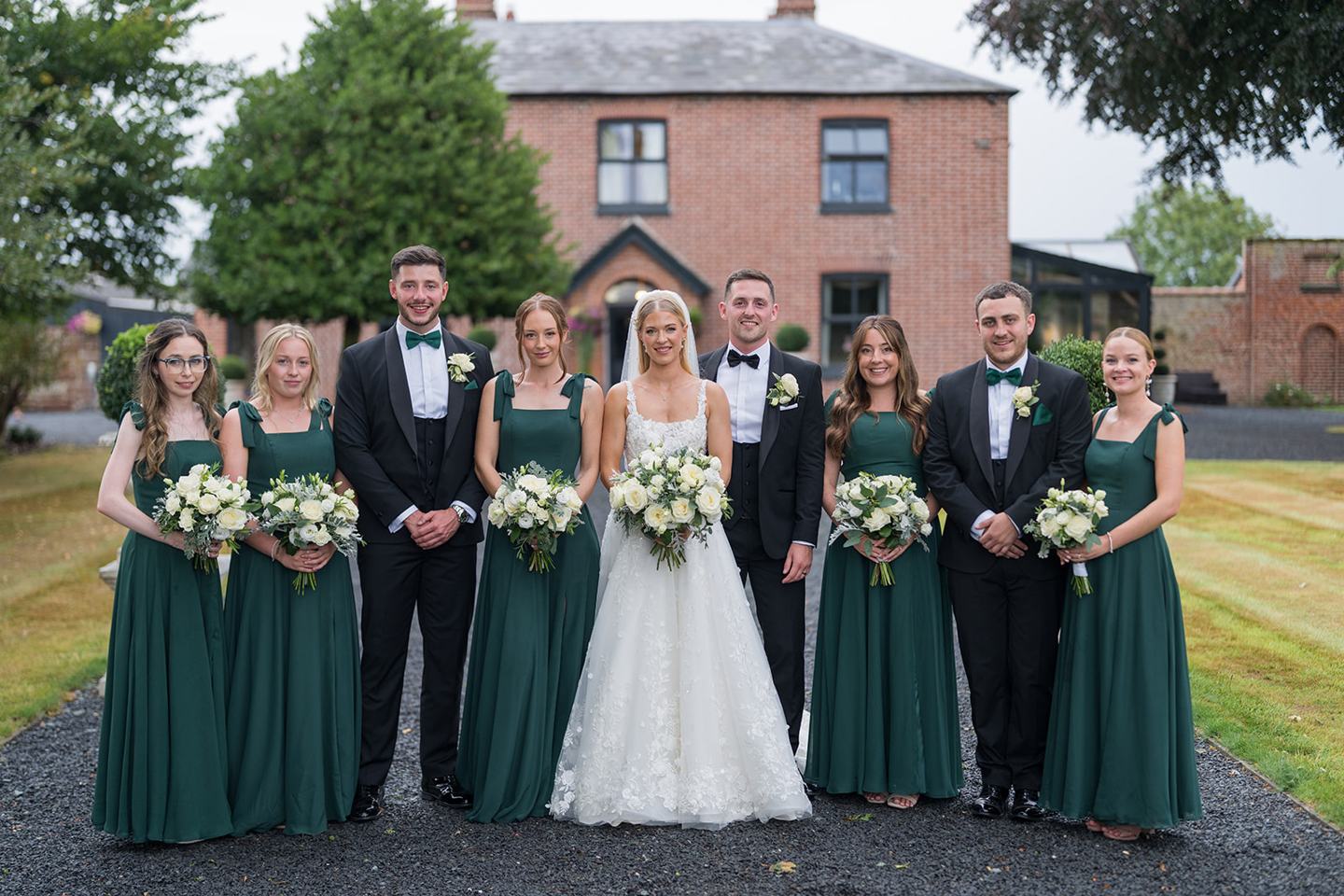 Bride and bridesmaids outside the manor at Evie and Josh’s Burlton Manor wedding