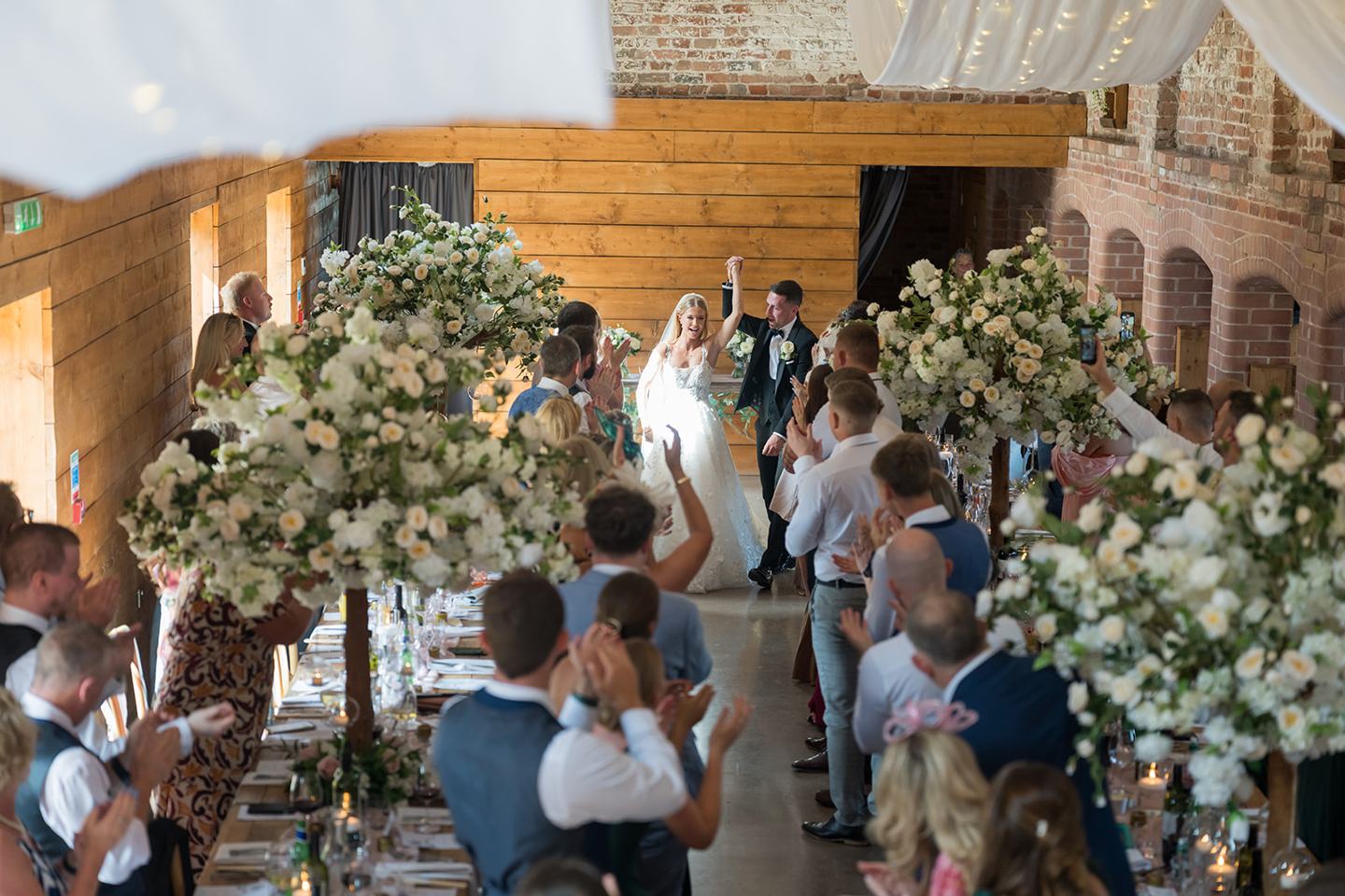 Guests celebrating at the reception at Evie and Josh’s Burlton Manor wedding