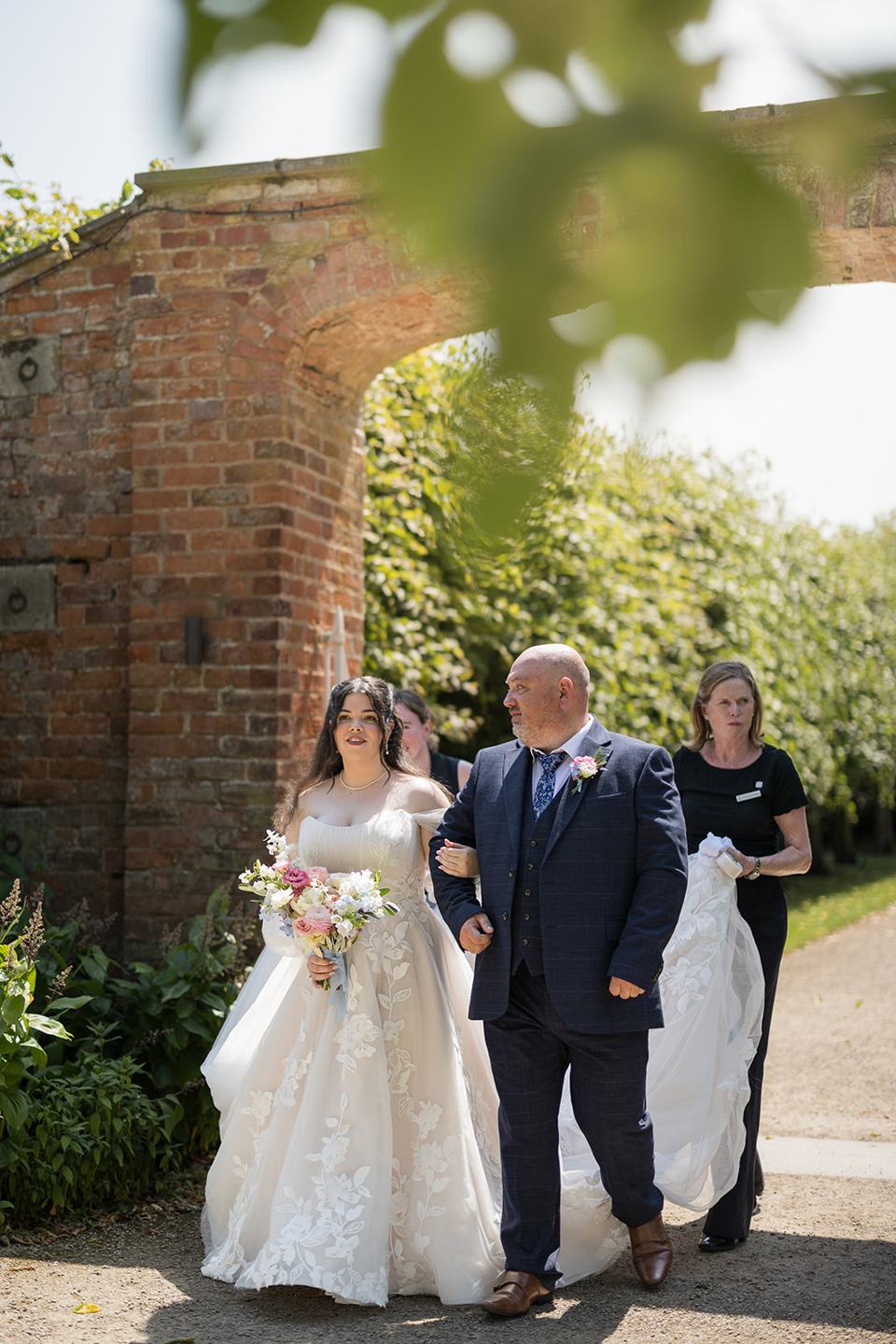 Bride arriving through the walled garden at Abi and Ben’s Combermere Abbey wedding