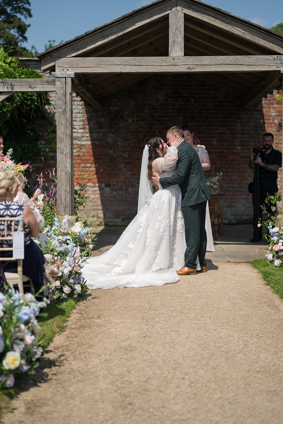 First kiss beneath the pavilion at Abi and Ben’s Combermere Abbey wedding