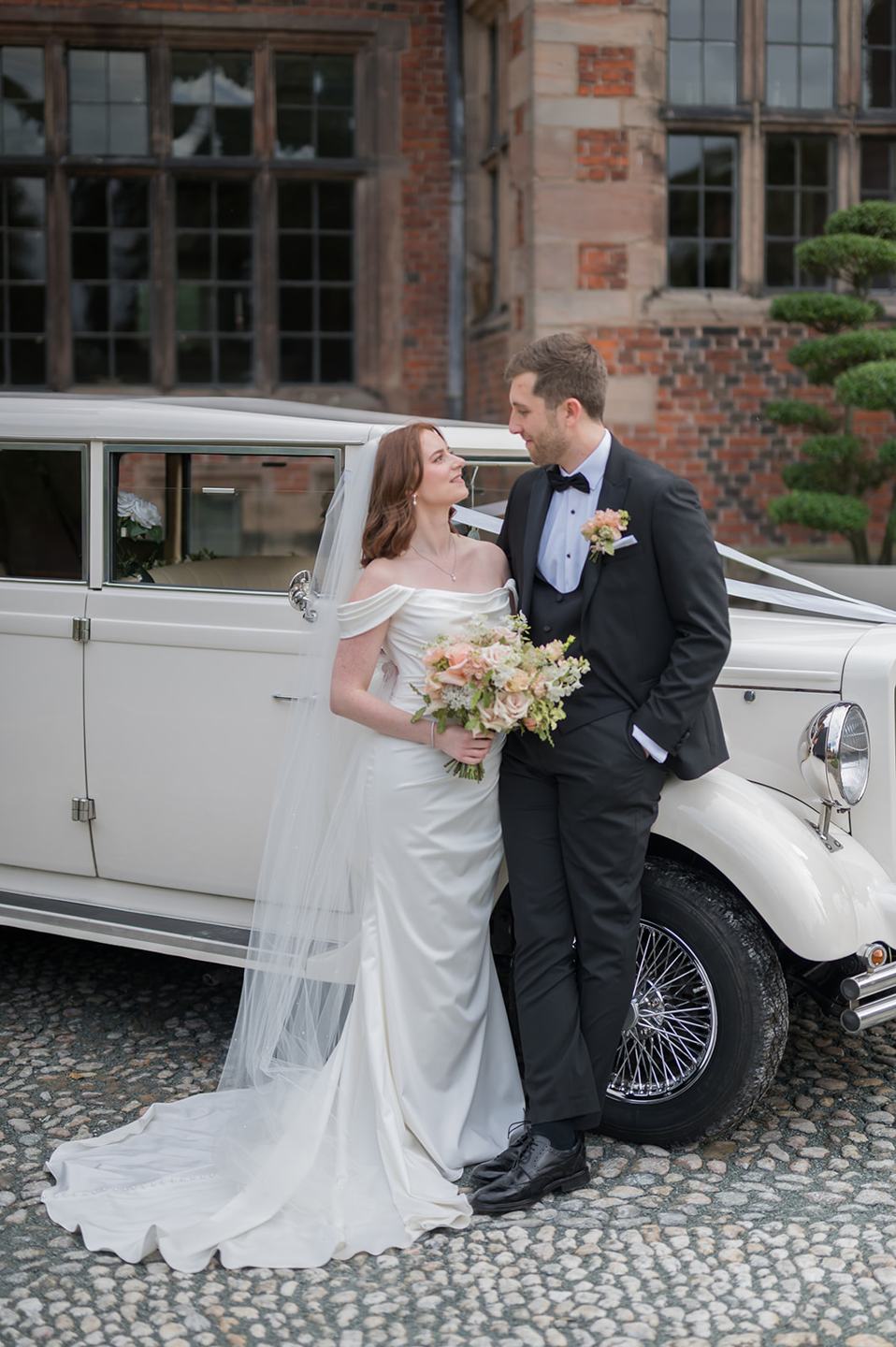Newlyweds beside their wedding car at Louise and Ben’s Dorfold Hall wedding
