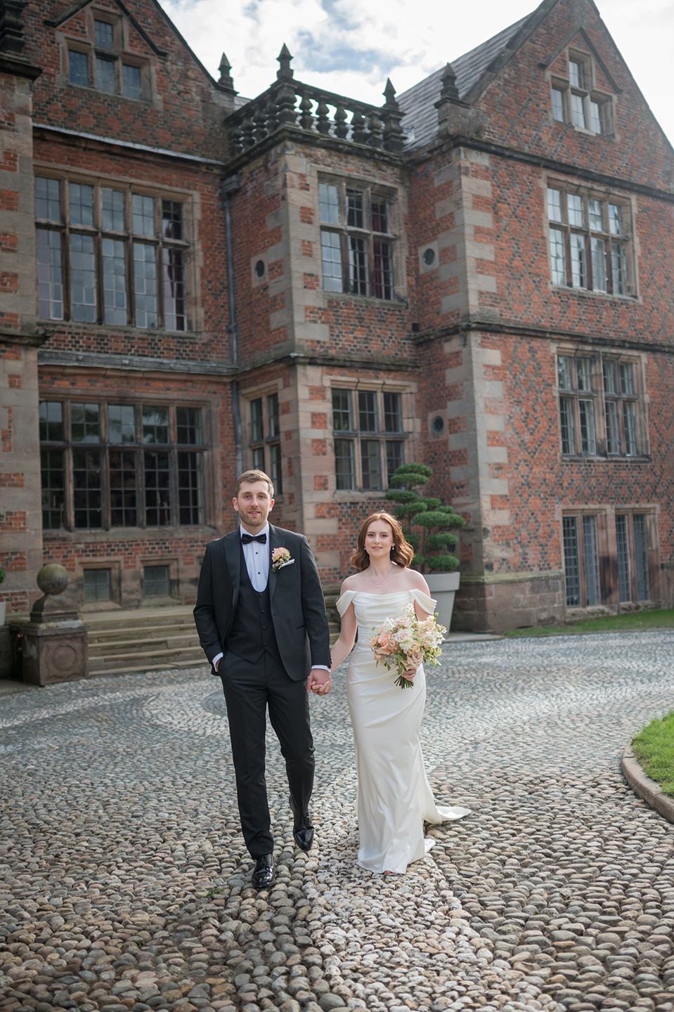 Walking outside the hall at Louise and Ben’s Dorfold Hall wedding