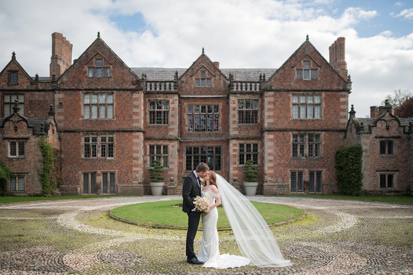 A portrait in front of the hall at Louise and Ben’s Dorfold Hall wedding