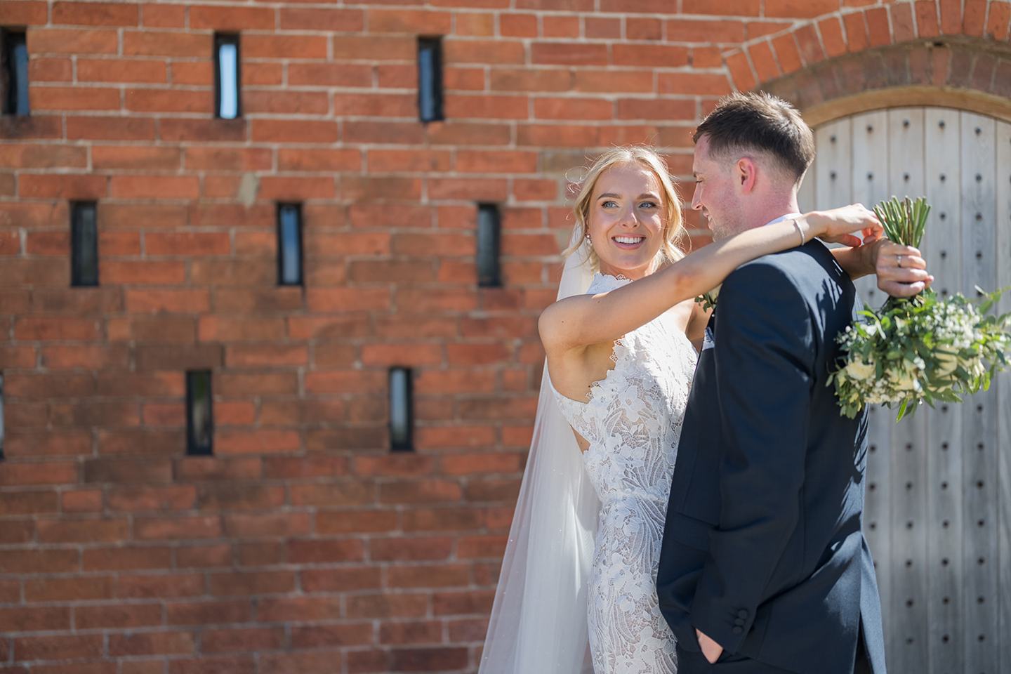A kiss beside the barn at Emma and Jack’s Grangefields wedding