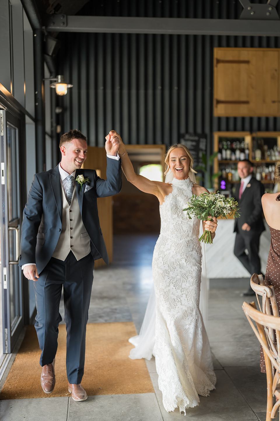 Newlyweds entering the reception at Emma and Jack’s Grangefields wedding