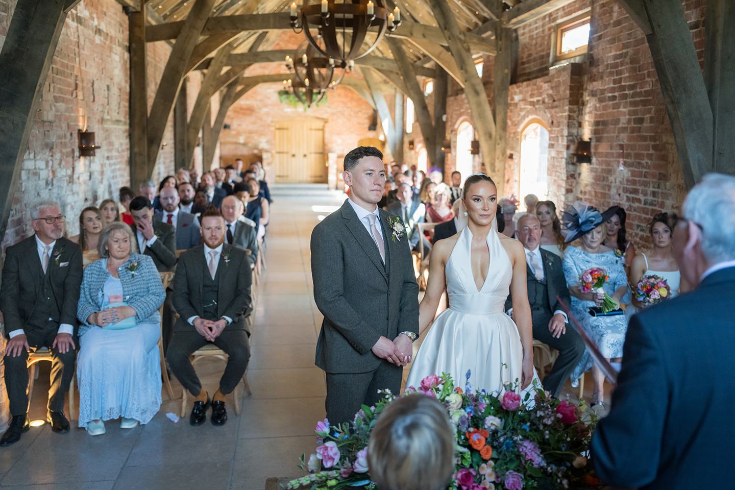 Wedding ceremony beneath timber beams at Georgie and Matt’s Grangefields wedding