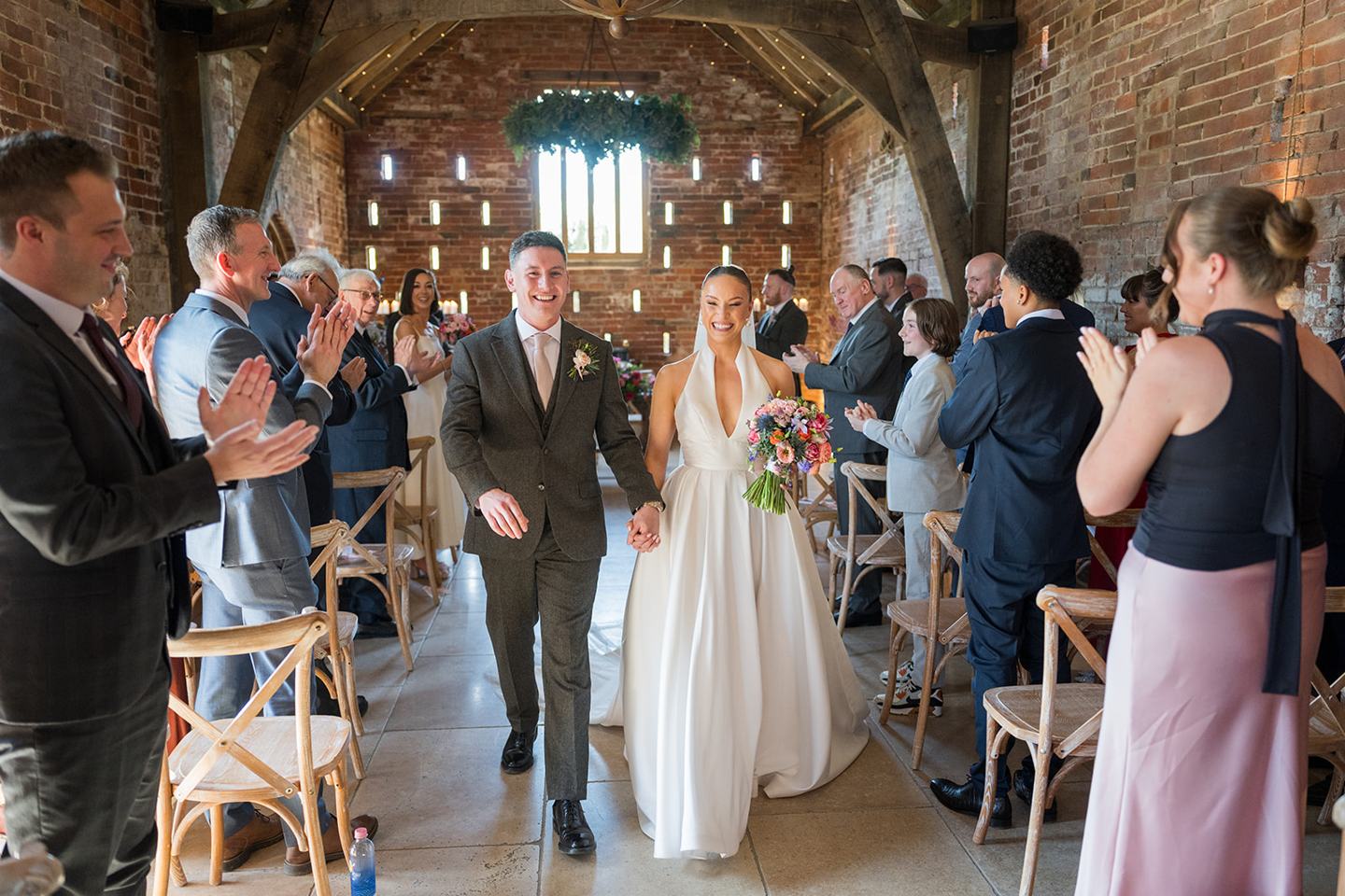 Newlyweds walking out of the ceremony at Georgie and Matt’s Grangefields wedding