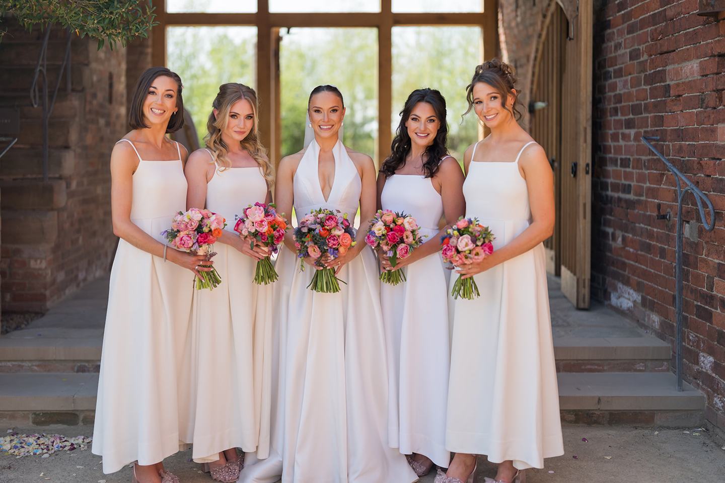 Bride and bridesmaids in the barn doorway at Georgie and Matt’s Grangefields wedding