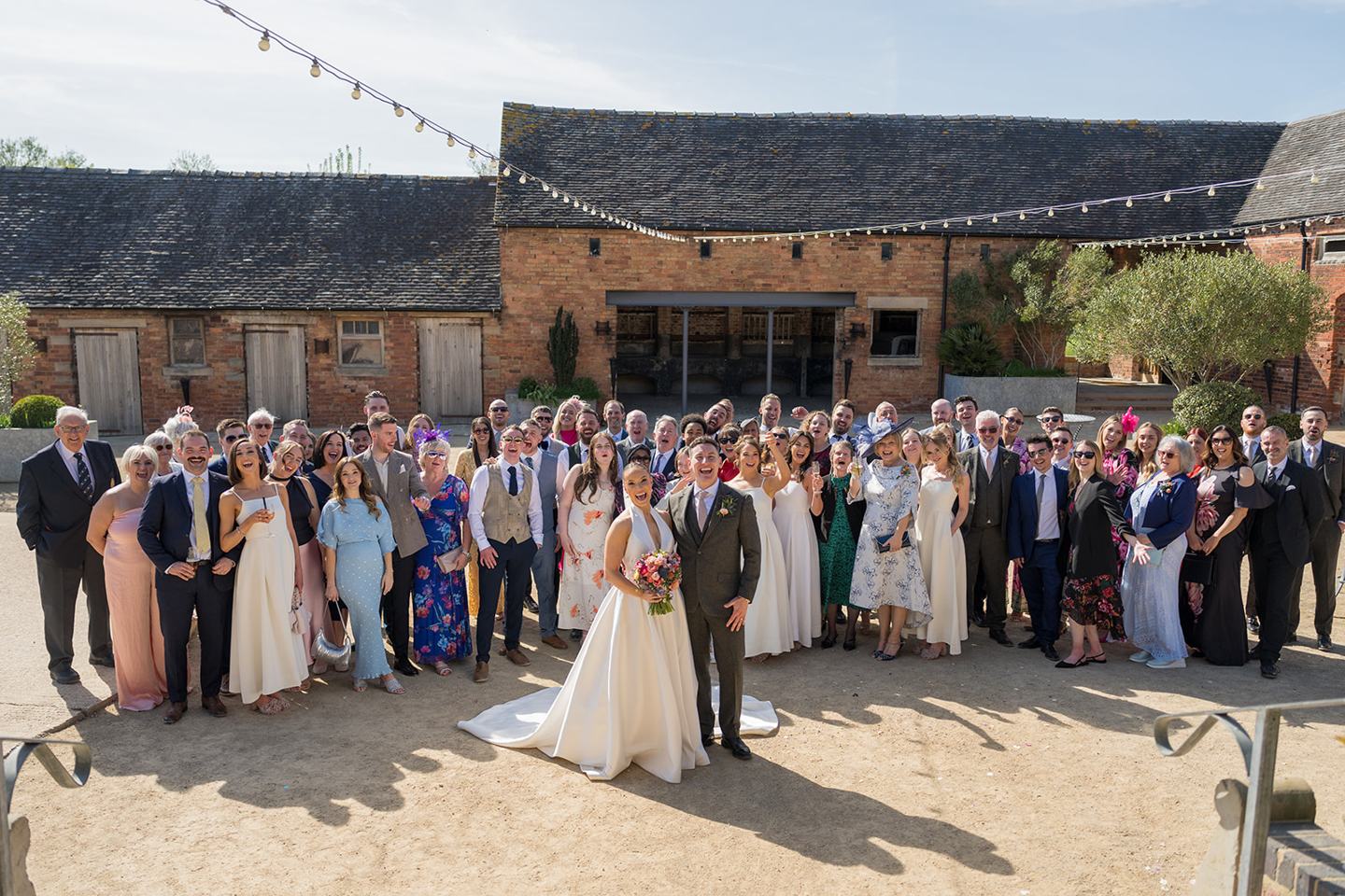 Wedding guests gathered in the courtyard at Georgie and Matt’s Grangefields wedding