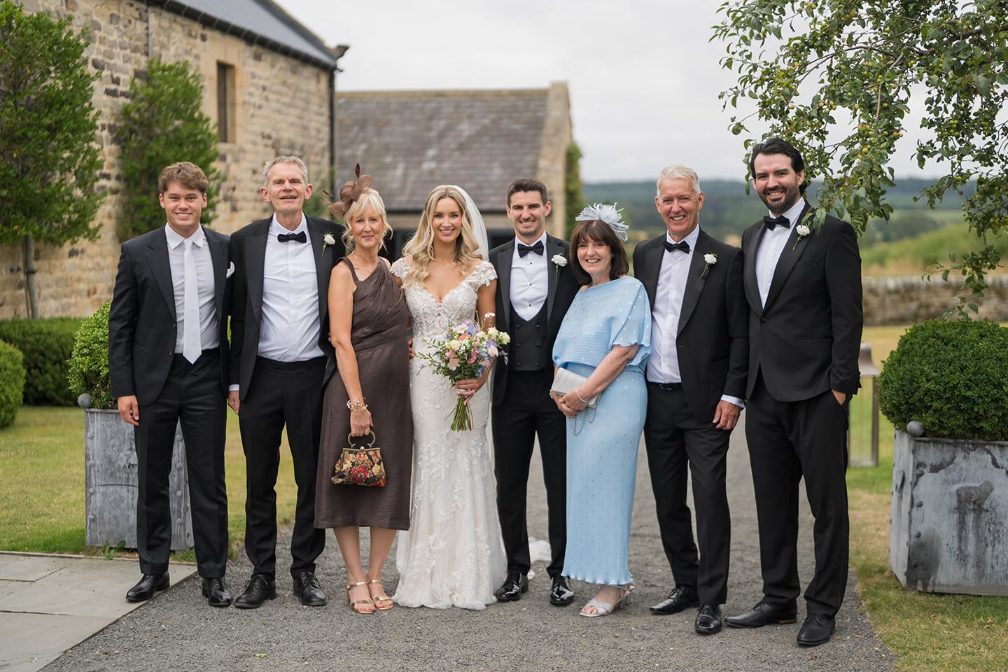 Family photograph outside the venue at Sophie and Sam’s Healey Barn wedding