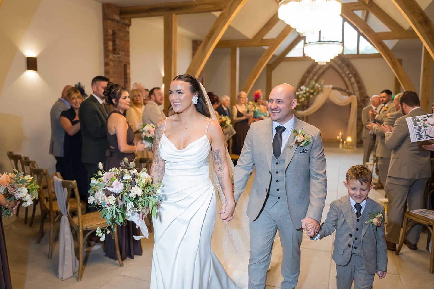 Newlyweds leaving the ceremony at Sally and Callum’s Hornington Manor wedding