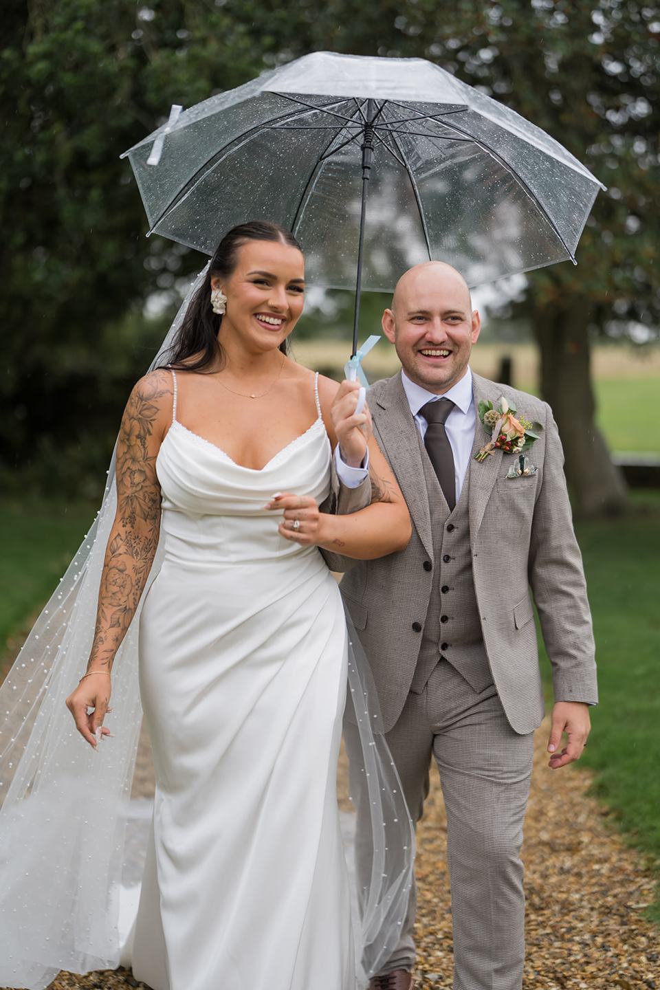 Newlyweds sharing an umbrella at Sally and Callum’s Hornington Manor wedding