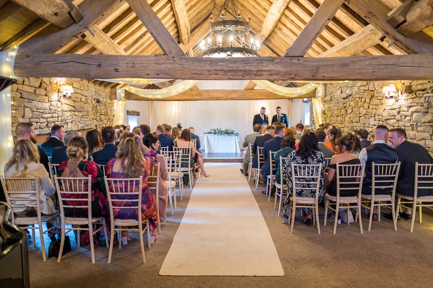 Guests gathered in the ceremony barn at Harriet and Gareth’s Hyde Bank Farm wedding