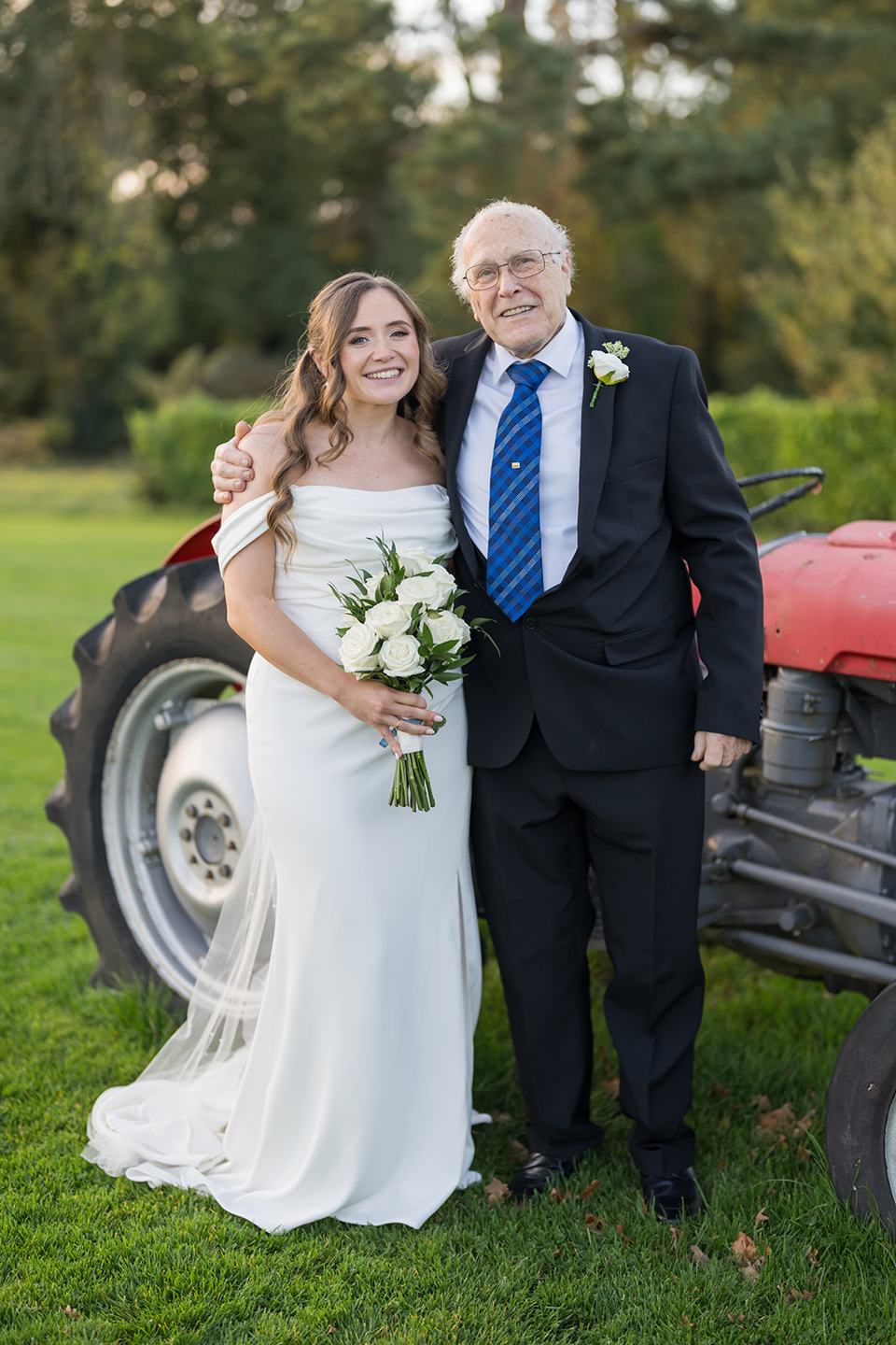 Bride and her father beside the tractor at Harriet and Gareth’s Hyde Bank Farm wedding