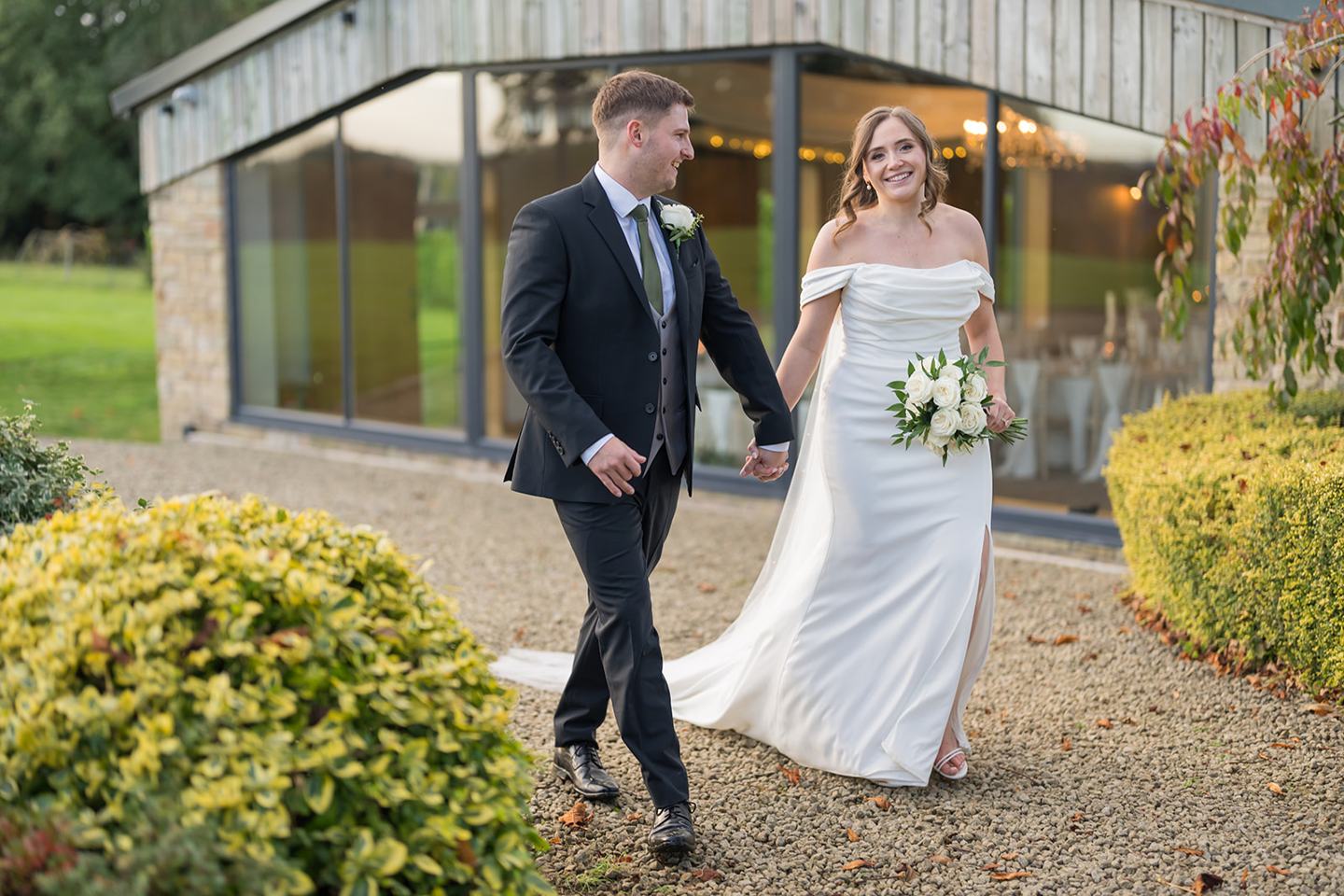 Couple outside the reception building at Harriet and Gareth’s Hyde Bank Farm wedding