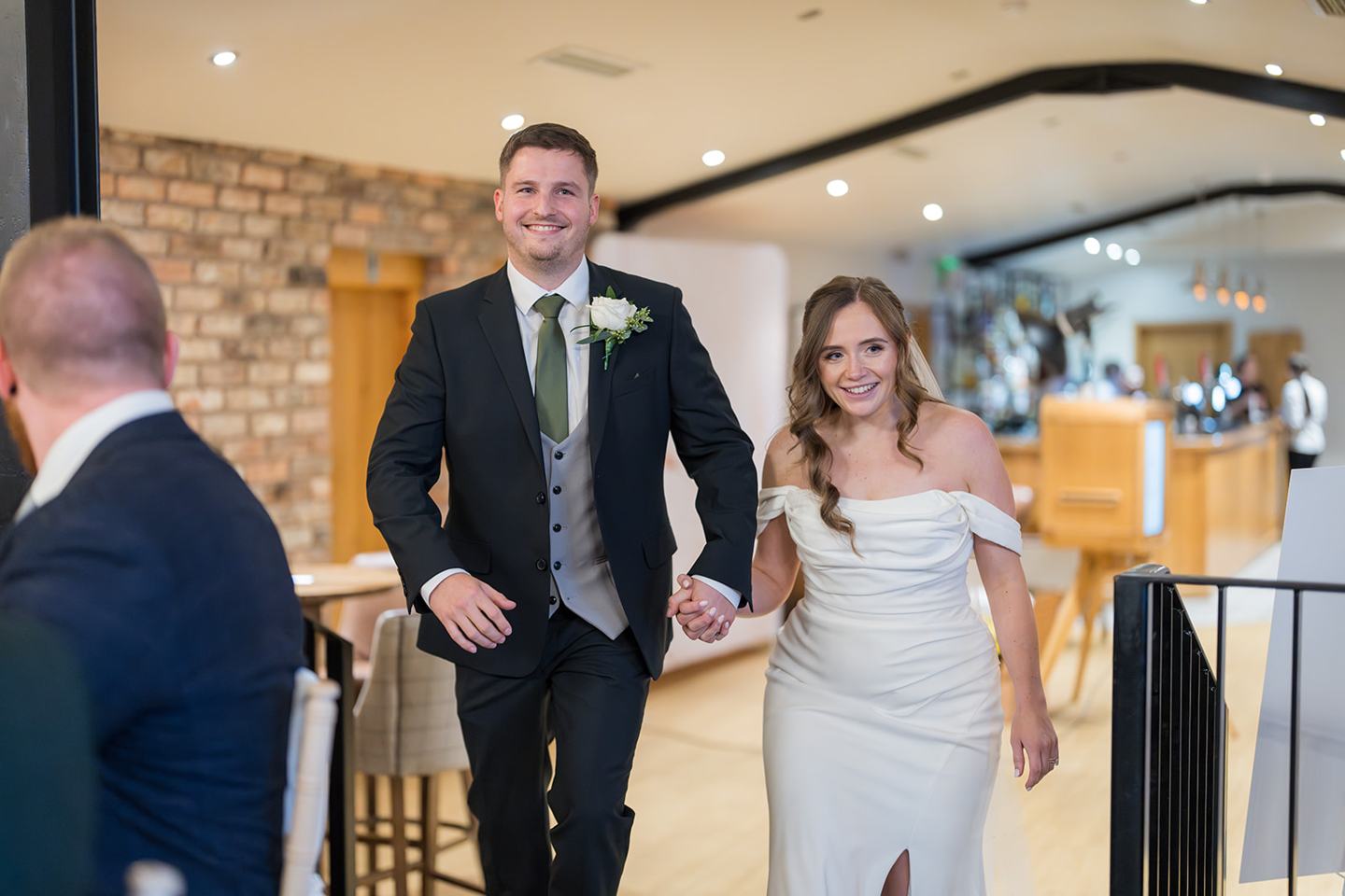 Couple entering their wedding reception at Harriet and Gareth’s Hyde Bank Farm wedding