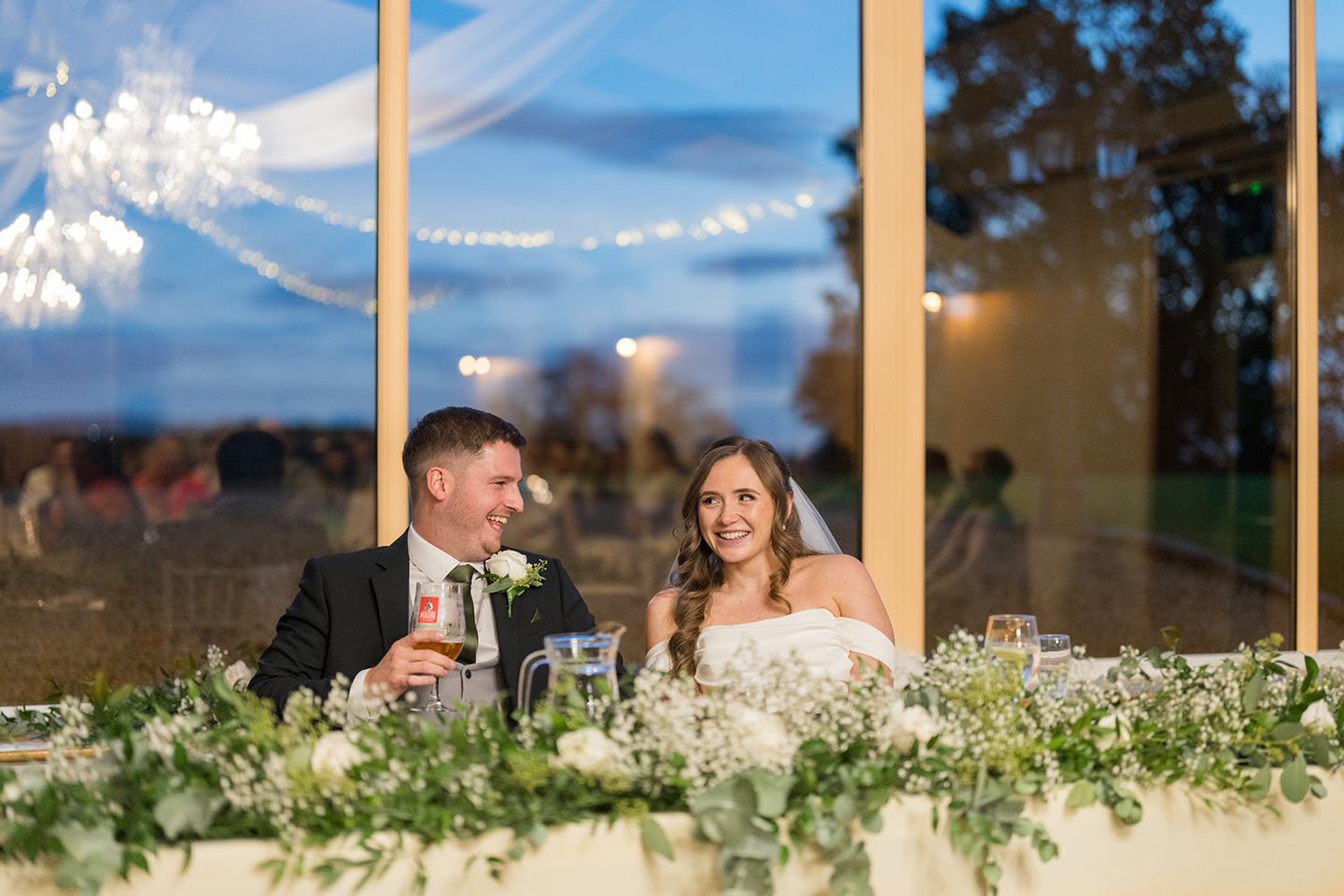 Couple enjoying the speeches at Harriet and Gareth’s Hyde Bank Farm wedding
