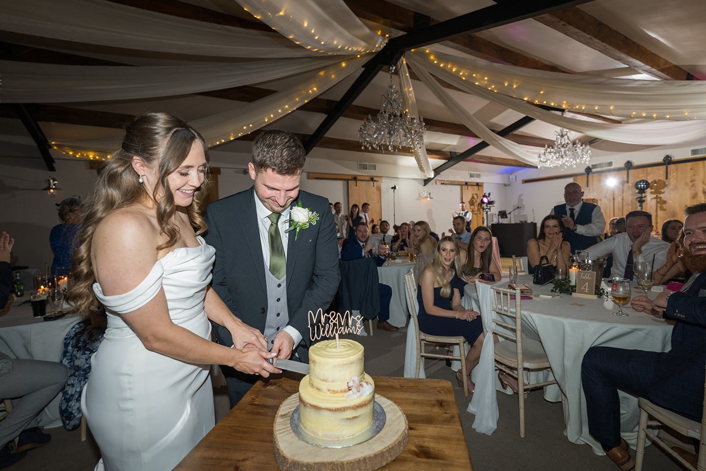 Cutting the wedding cake at Harriet and Gareth’s Hyde Bank Farm wedding