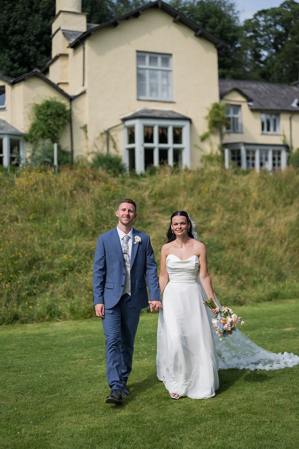 Newlyweds with Lancrigg behind them at Alex and Dan’s Lancrigg wedding