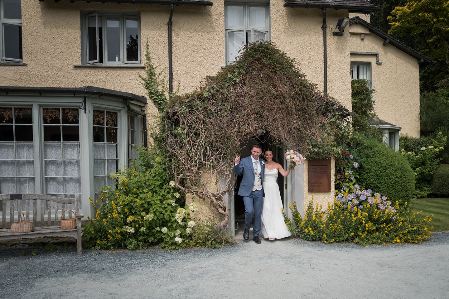 Couple outside the ivy-covered entrance at Alex and Dan’s Lancrigg wedding