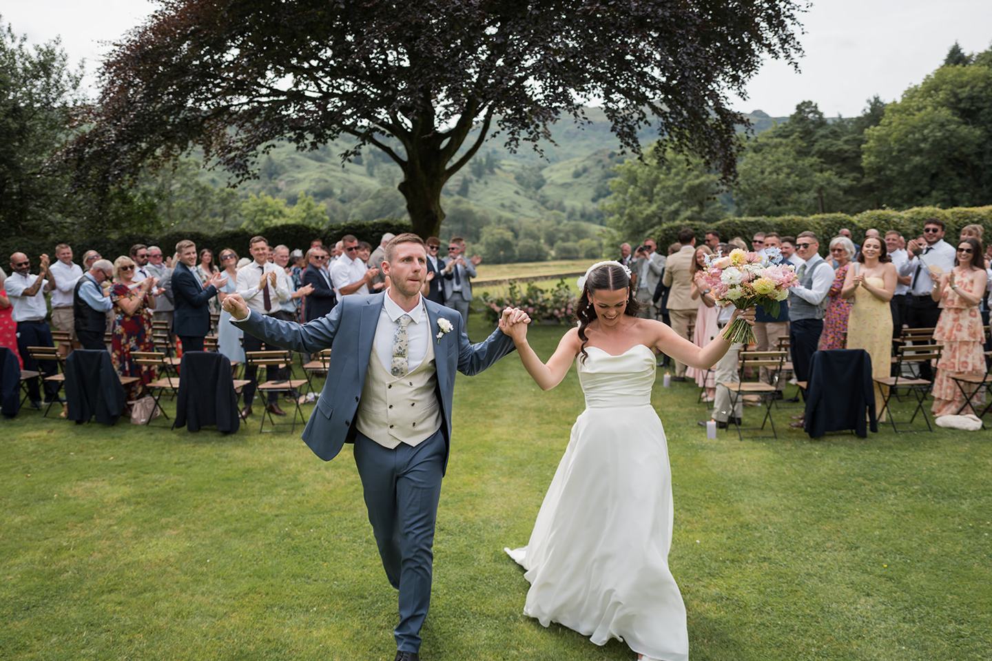 Newlyweds celebrating after the ceremony at Alex and Dan’s Lancrigg wedding