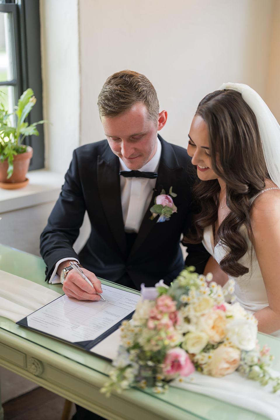 Signing the register at Becky and Alex’s Middleton Lodge wedding